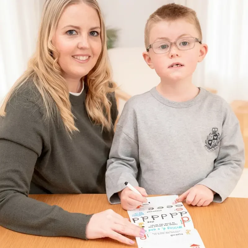 Key Worker and child smiling at the camera, showing how education support services create trust, confidence, and positive relationships.