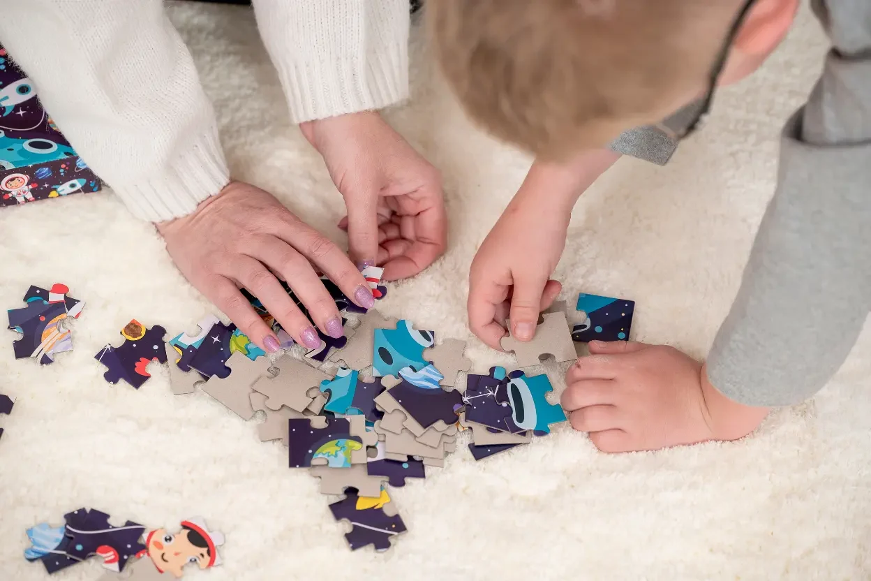 About The Child Centred Learning Tree – adult and child playing with a jigsaw puzzle, representing learning and family support. puzzle play support