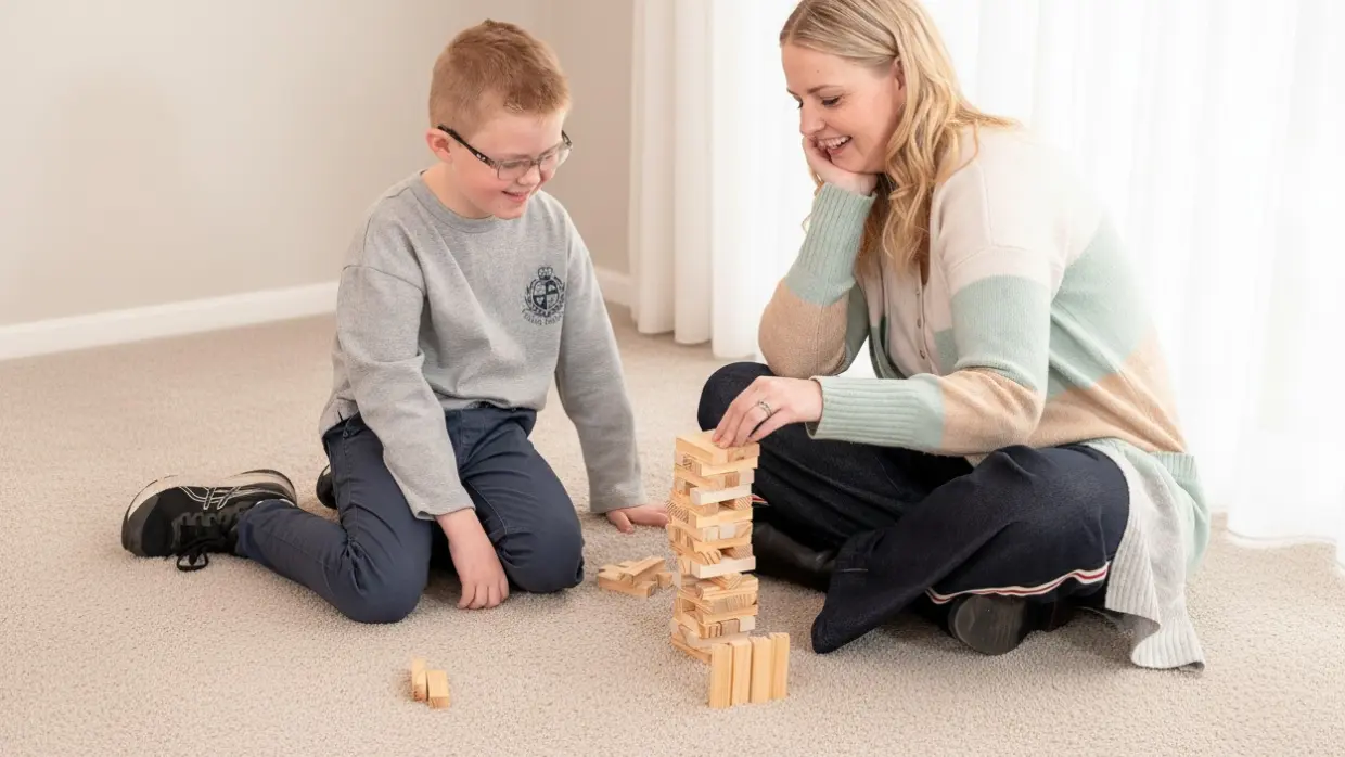 Child and adult playing Jenga at home, representing education support services that build skills through play and family connection.